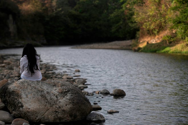 A woman sits on the banks of the polluted Lempa River in Pinuelas, Honduras, on January 11, 2019. (Marvin Recinos/AFP/Getty Images/TNS)