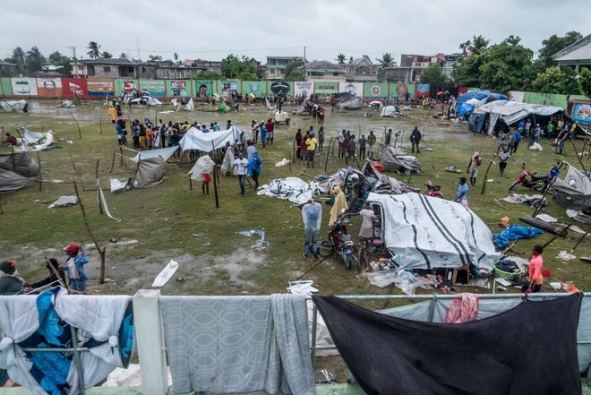 People make repairs and create a shelter, after spending the night outside in the aftermath of the earthquake, in the face of the inclement weather of Tropical Storm Grace near Les Cayes, Haiti on August 17, 2021.