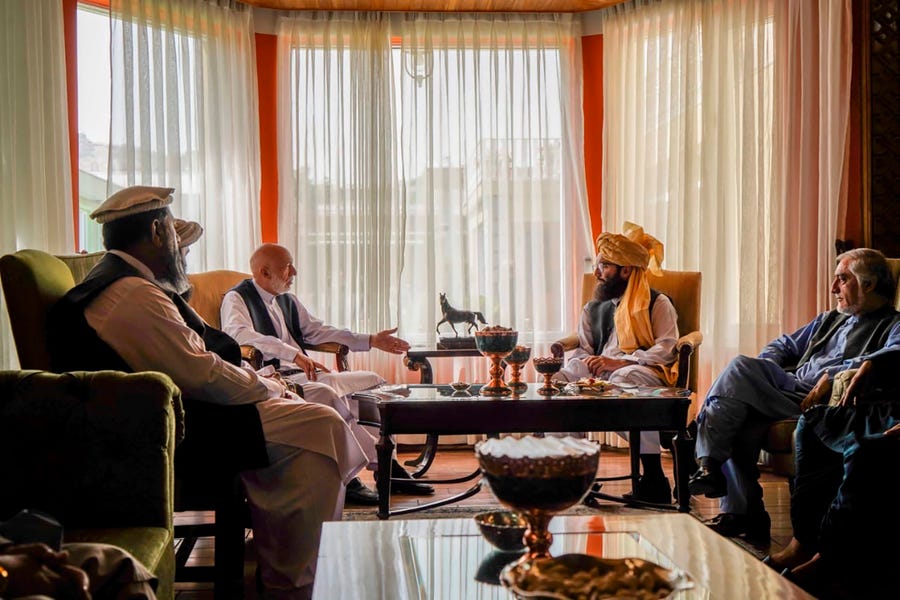 In this handout photograph released by the Taliban, former Afghan President Hamid Karzai, center left, senior Haqqani group leader Anas Haqqani, center right, and Abdullah Abdullah, head of Afghanistan's National Reconciliation Council and former government negotiator with the Taliban, right, meet in Kabul, Afghanistan, Wednesday, Aug. 18, 2021. The meeting comes after the Taliban's lightning offensive saw the militants seize the capital, Kabul.