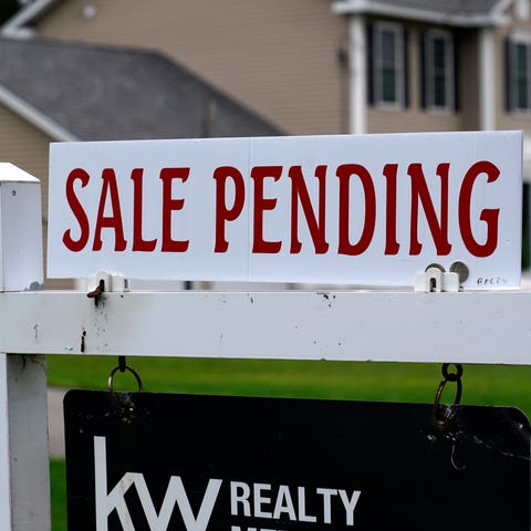A "sale pending" sign is posted outside a single f