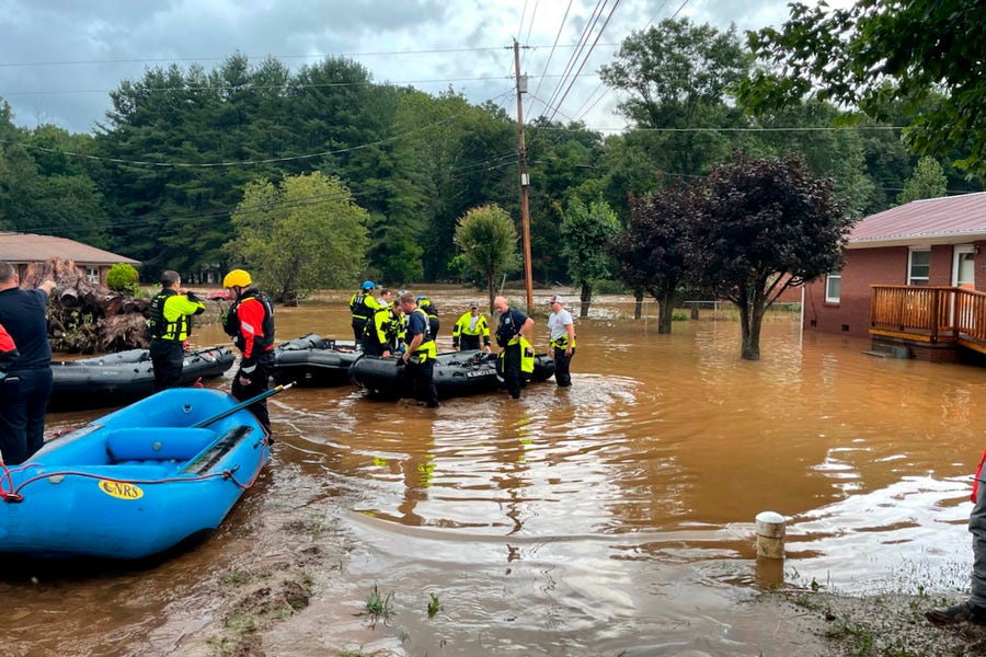 In this image provided by New Hanover County Fire Rescue, members of North Carolina's Task Force 11, based in New Hanover County, are shown during rescue efforts in Canton, N.C, on Tuesday, Aug. 17, 2021. Authorities said that dozens of water rescues were performed after the remnants of Tropical Storm Fred dumped rain on the mountains of North Carolina.