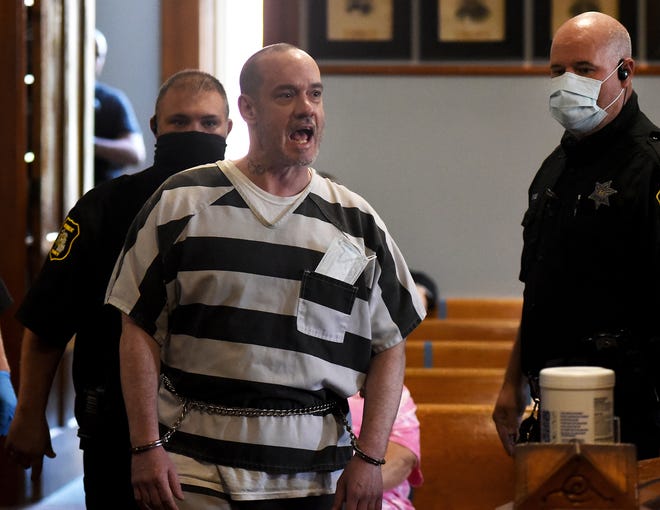 Kenny W. McBride, 45, of Temperance yells at 38th Circuit Court Chief Judge Michael  A. Weipert as he is escorted into Weipert's courtroom Thursday by several Monroe County Sheriff's deputies. McBride was sentenced to life in prison for the murder of Cecilia "Nickie" Gibson.