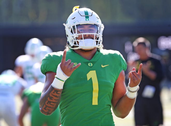 Gelandang dalam Oregon Noah Sewell membuat gerakan shaka (menggantung) Hawaii dengan tangannya saat ia bergabung dengan timnya dalam pemanasan selama Perkemahan Musim Gugur dengan Bebek.