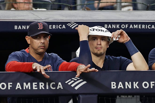 Boston Red Sox manager Alex Cora, left, and Enrique Hernandez watch from the dugout during the Red Sox's 5-2 loss against the New York Yankees on Wednesday in New York.