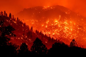 Seen in a long exposure photograph, embers light up hillsides as the Dixie Fire burns near Milford in Lassen County, Calif., on Tuesday, Aug. 17, 2021. (AP Photo/Noah Berger)