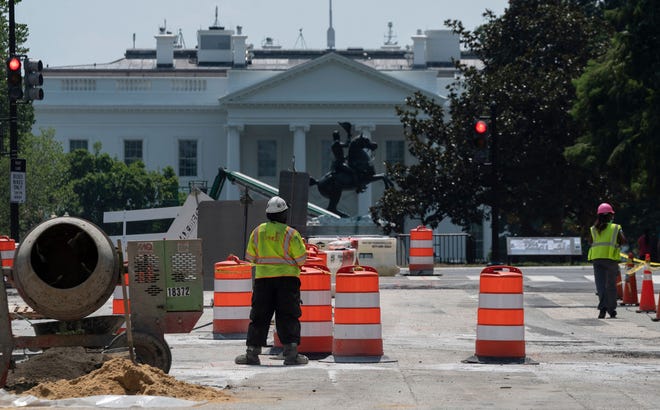 In this file photo taken on August 10, 2021, construction workers repair a street near the White House in Washington, DC. - The number of US workers filing applications for unemployment benefits continues to trend downward, with another sharp drop last week, according to government data released on August 12, 2021.