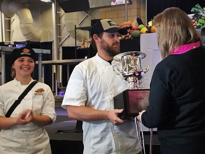 Chef Theron Jessop receives the 2021 Oklahoma Restaurant Association Culinary Cook-Off trophy along with his assistant Gabby McKinley of Oklahoma State Institute of Technology on Thursday during the ORA's annual convention and expo at the State Fairgrounds.