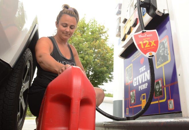 Michelle Crandall of Lisbon gets gas for the family generator Friday at the Shell Henny Penny in Lisbon in preparation of a possible hurricane this weekend.