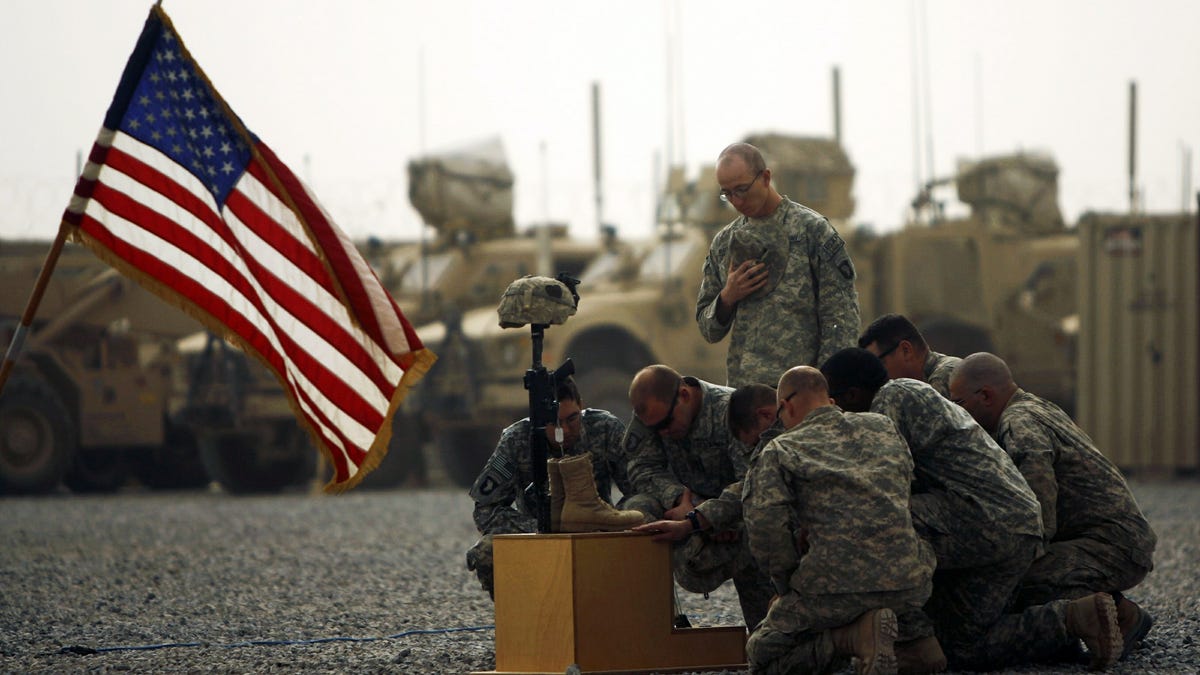 This file photo taken on September 14, 2010 shows U.S. army officers with the 101st Airborne Division paying their respects by the boots, gun, helmet and dog tags of U.S. army First Lieutenant Todd W. Weaver displayed during a memorial ceremony in his honor at Combat Outpost Terra Nova on the outskirts the Arghandab Valley's Jellawar village.