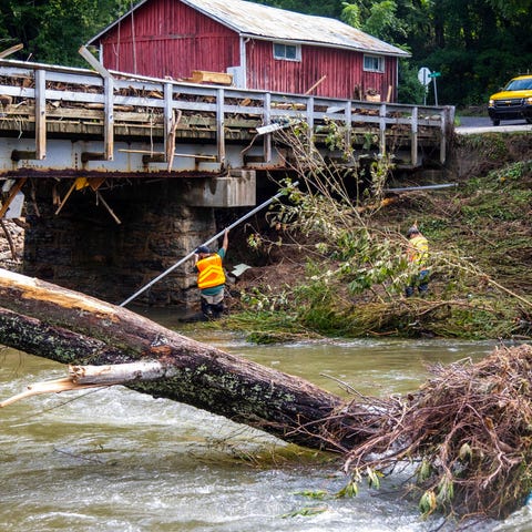 NCDOT workers assess damage to a bridge spanning t