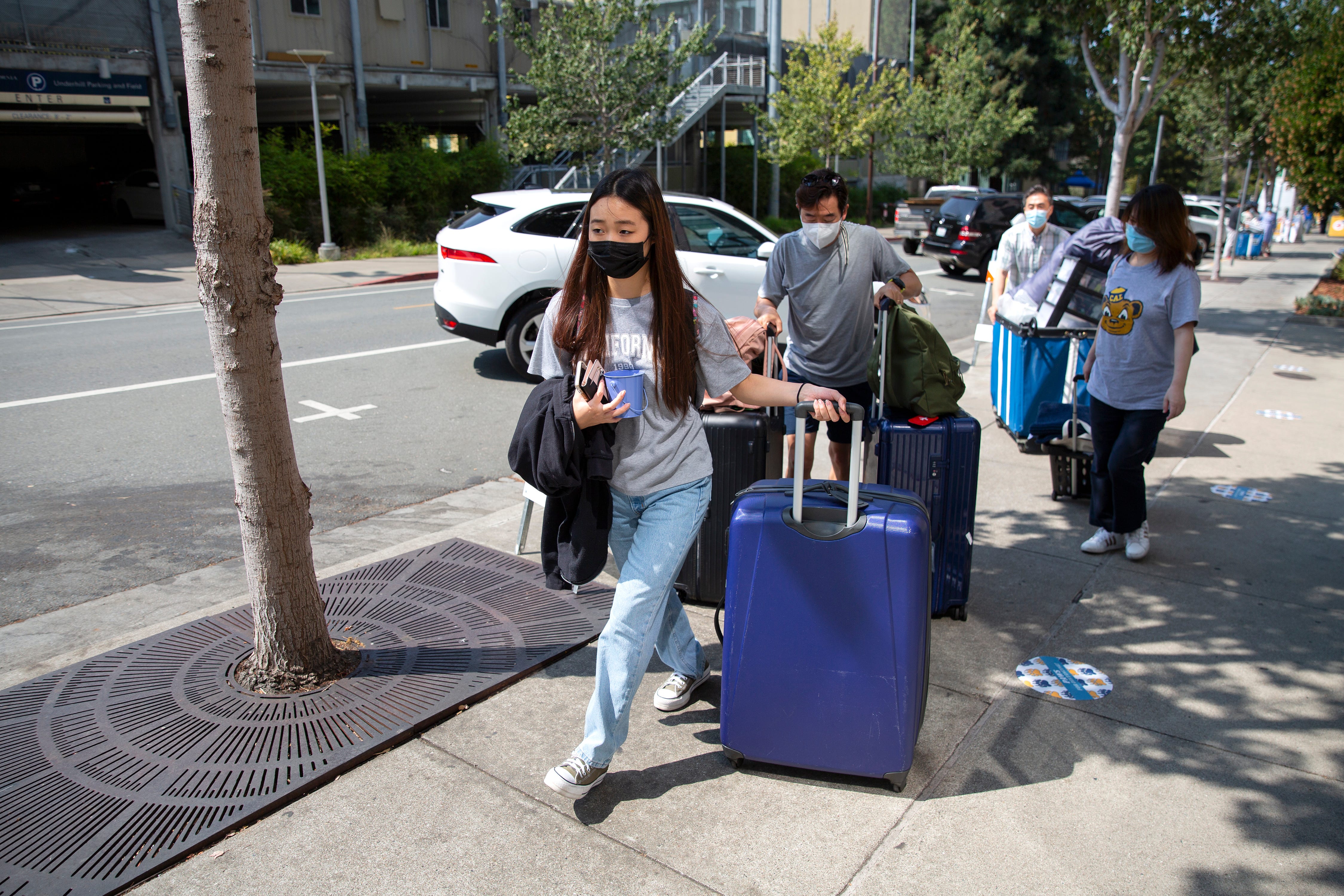 Daniella Choi, 18 from Los Angeles, pulls a suit case up to her dorm building as  she moves in on campus at the University of California, Berkeley on Aug. 16, 2021.