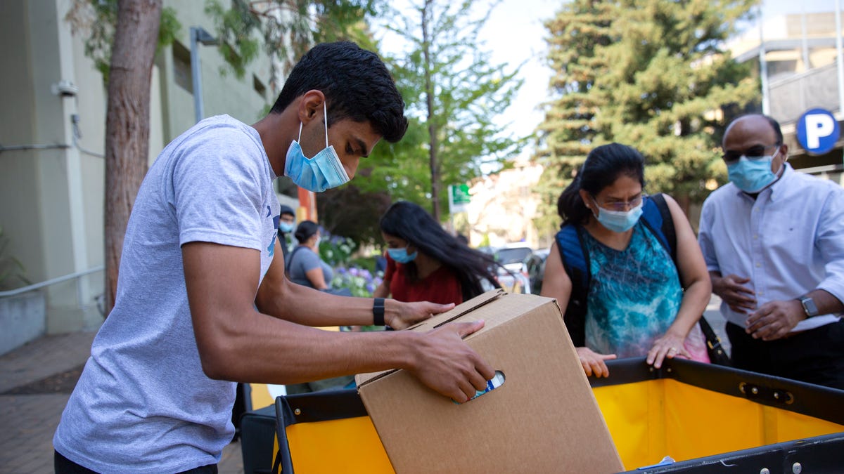 Akshay Talked, 18, loads up person belongings in a cart with his family as he moves in on campus at the University of California, Berkeley on Aug. 16, 2021.