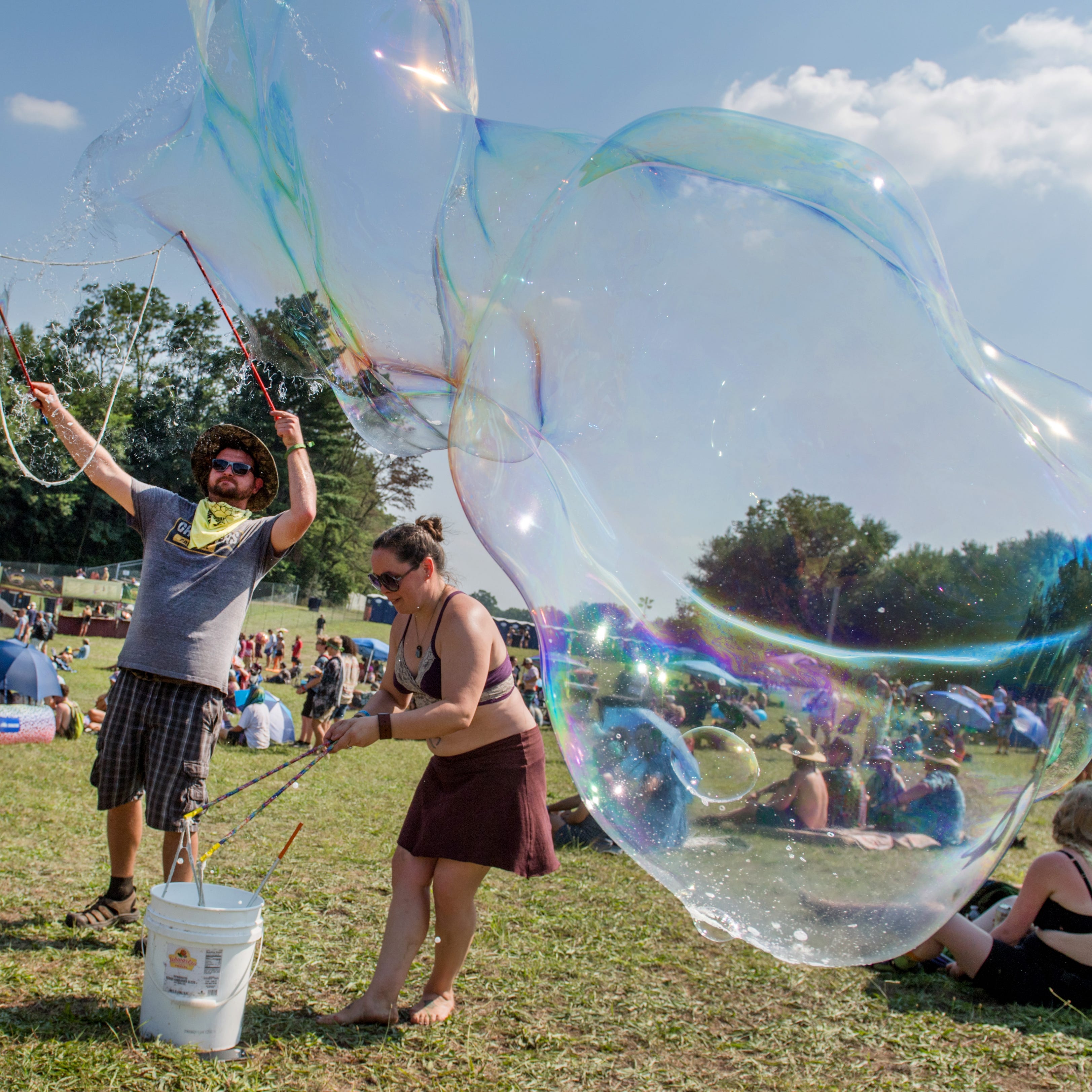 Nick Brown of the Quad Cities and Heather Wamsley of Davenport create some giant bubbles as they take a moe. concert Friday, Aug. 20, 2021 during the Summer Camp Music Festival at Three Sisters Park in Chillicothe.