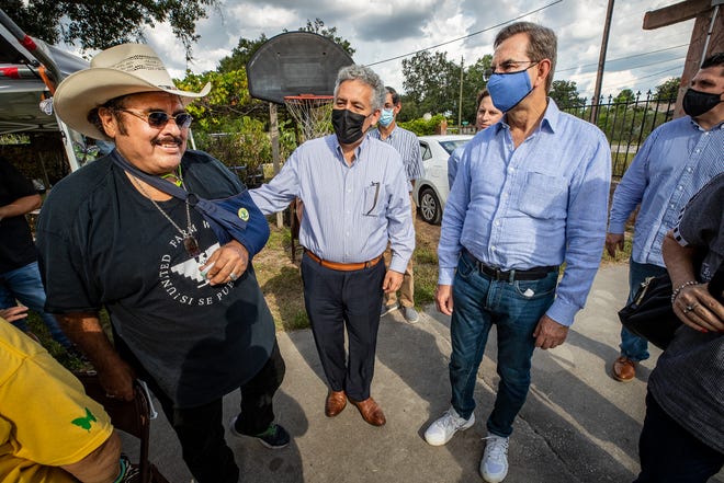 Hilario Barajas, left, greets Mexican Ambassador Esteban Moctezuma Barragán, right, and Mexican Consul Juan Sabines Guerrero, center, as they tour and visit the Young American Dreamers headquarters at Barajas' home in Auburndale.