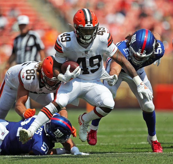 Cleveland Browns running back John Kelly (49) breaks away from New York Giants defensive end Niko Lalos (57) and New York Giants linebacker Devante Downs (52) as he rushes for a first down during the second half of an NFL preseason football game, Sunday, Aug. 22, 2021, in Cleveland, Ohio. [Jeff Lange/Beacon Journal]