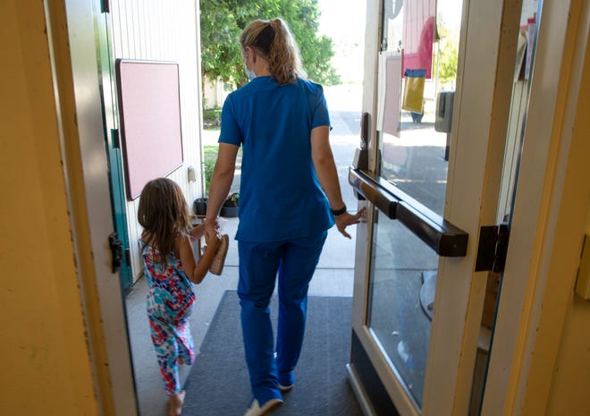 Lane Community College medical student Laci Almeliky, 32, right, picks up her daughter, Layla, 4,  from daycare after classes.