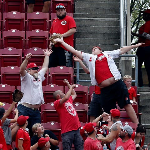 Fans reach for a home run ball off the bat of Cinc