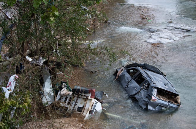 A flooded car and debris rest in Trace Creek Monday, Aug. 23, 2021 in Waverly, Tenn.  As much as 17 inches of rain hit Humphreys County Saturday, causing flood waters to surge throughout the area killing at least 18 people.