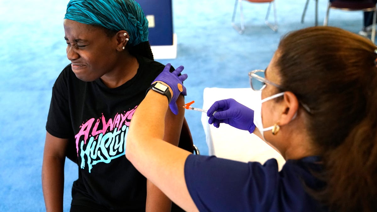 Student Rose Jean-Mary, 19, receives a shot of the Pfizer COVID-19 vaccine from registered nurse Isabel Ruiz at St. Thomas University on Aug. 20 in Miami. The university offered a pop-up vaccination site for students on move-in day in preparation for the first day of school Aug. 23.