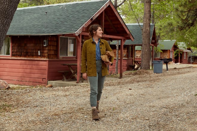 Lindsey Kurowski poses in front of cabins at the Oak Knoll Lodge, a property in Big Bear Lake, California that she restores for "Inn the Works," streaming on the Magnolia and Discovery+ apps.