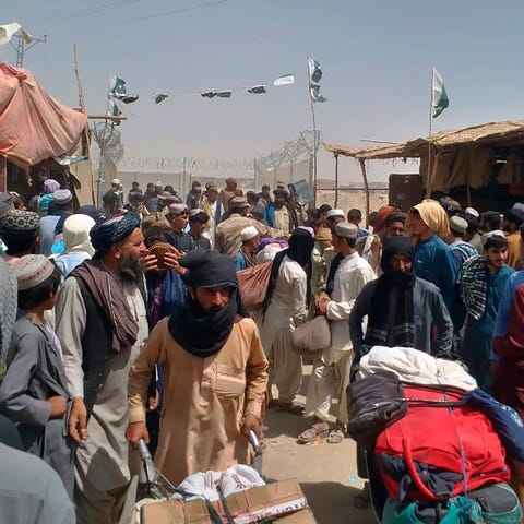 Afghan families enter Pakistan through a border cr