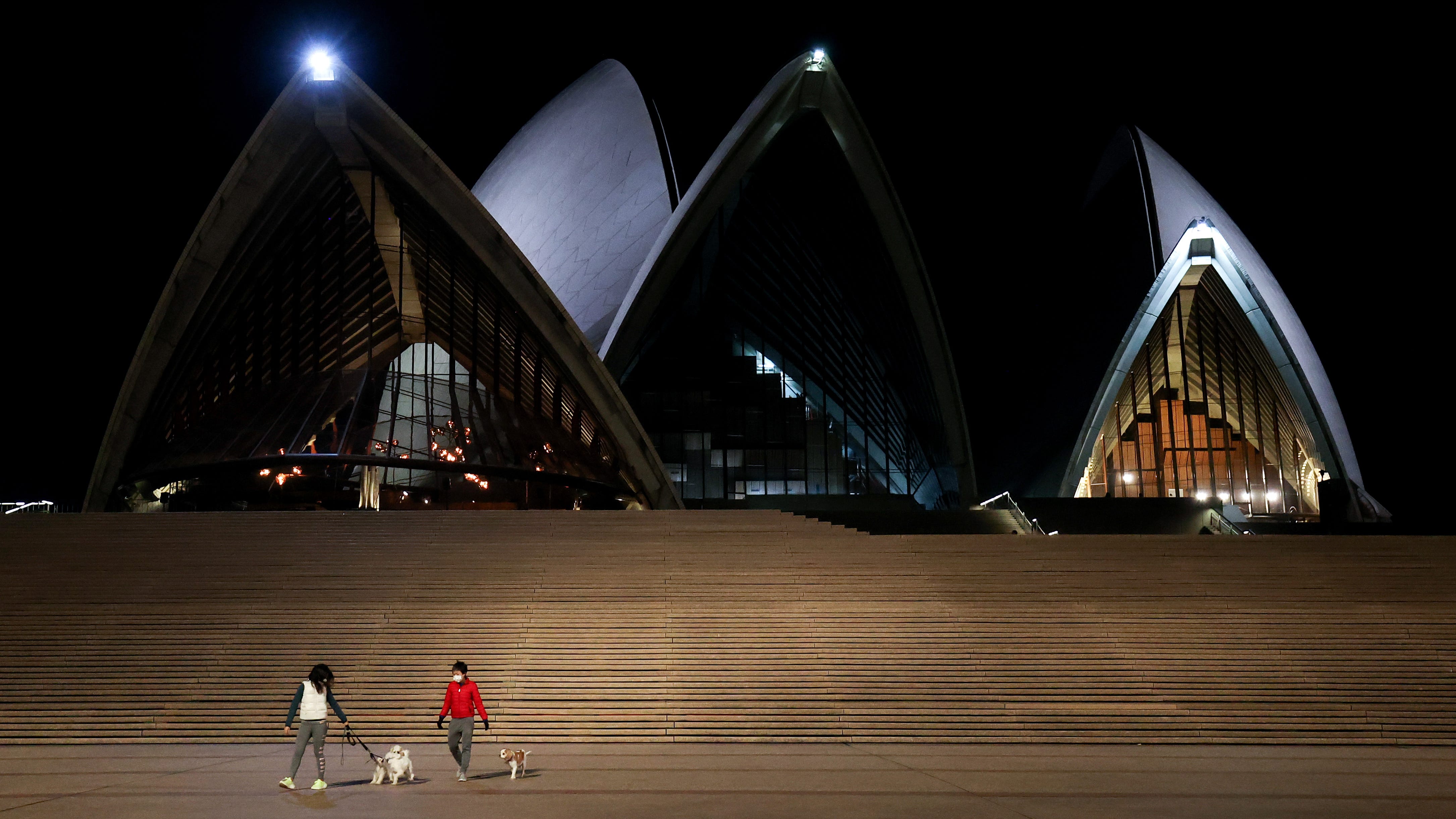 People walk dogs at an empty Sydney Opera House which is closed due to Covid-19 on June 26, 2021 in Sydney, Australia.