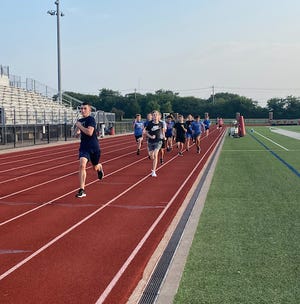 Heritage boys' cross-country runners get in some speed work during preseason practice on the HHS track.
