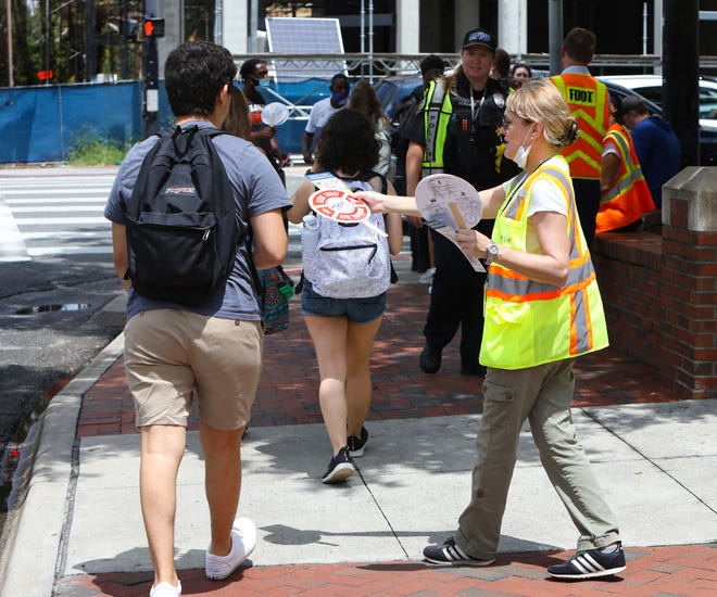 Debbie Delgado, an outreach specialist for the Florida Department of Transportation, handed out flyers Tuesday in Gainesville with information on how to stay safe on the roads while walking or biking.