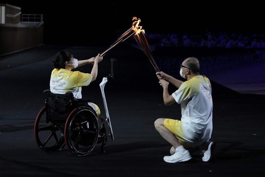 The Paralympic flame is passed between torchbearers during the opening ceremony for the Tokyo Paralympic Games at the Olympic Stadium on Aug. 24.