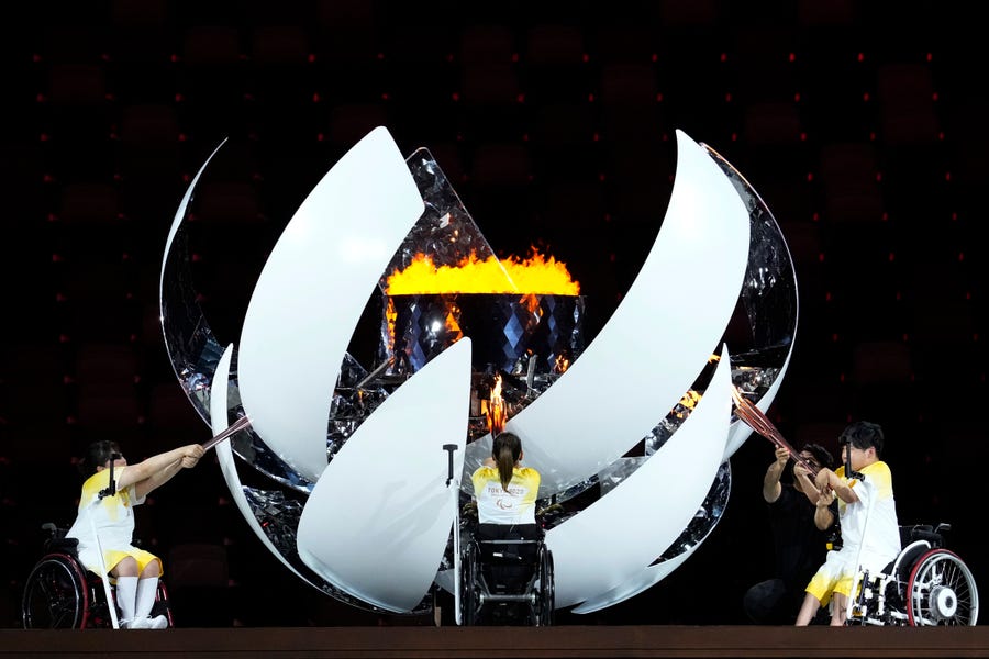 Japan's Yui Kamiji, centre, Shunsuke Uchida, right, and  Karin Morisaki light the Paralympic cauldron during the opening ceremony for the 2020 Paralympics at the National Stadium in Tokyo, Tuesday, Aug. 24, 2021. (AP Photo/Shuji Kajiyama) ORG XMIT: TOK572