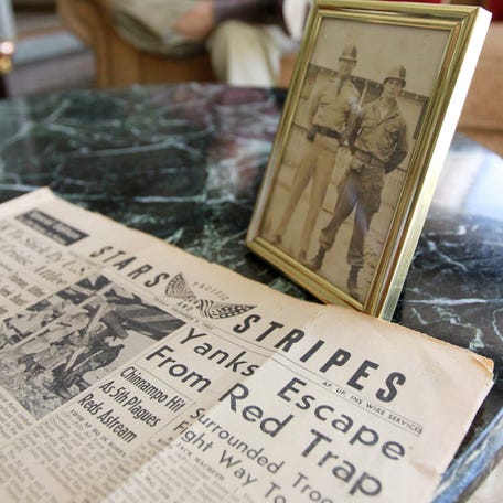A Stars and Stripes newspaper from the Korean War sits on a table next to a photo of a U.S. military veteran at his home in Lakeland, Florida, in 2011.