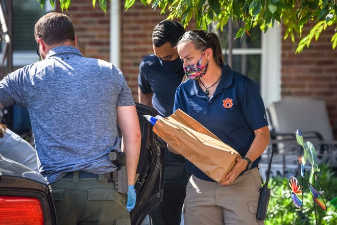 Investigators walk out of the home of Scott Benson in Detroit on Aug. 25, 2021.