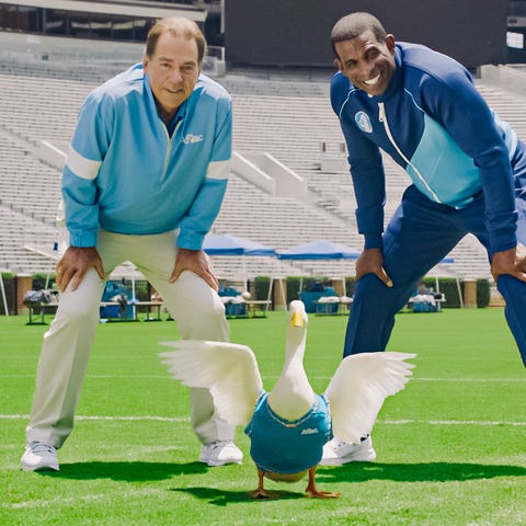 Nick Saban, the Aflac duck and Deion Sanders pose 