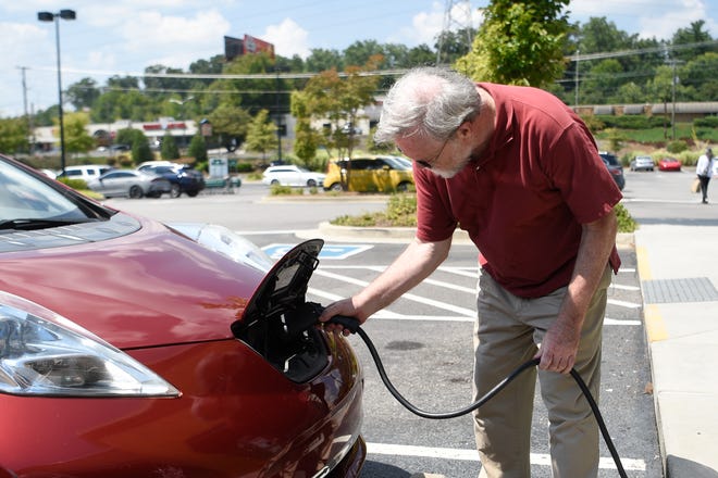 Rich Norby charges up his Nisan LEAF an electric vehicle, at Whole Foods on Papermill Drive in Knoxville, Tuesday, Aug. 25, 2021.