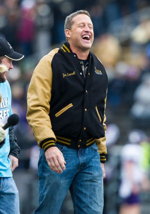 Purdue alumni and retired NFL quarterback Jim Everett walks off the field after being recognized during a break in the first half of an NCAA college football game, Saturday, Nov. 22, 2014, in West Lafayette, Ind. (AP Photo/Doug McSchooler)