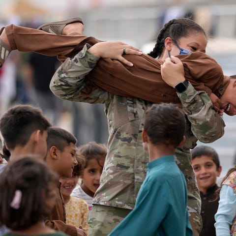 An U.S. soldier plays with recently evacuated Afgh