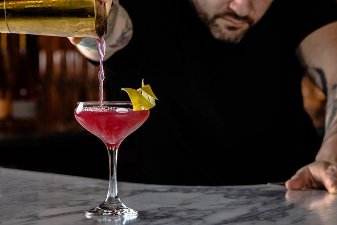 A Lady in Red cocktail is served at Ember Grill. The drink combines Angel's Envy bourbon, strawberry syrup, honey, lemon and Peychaud's Bitters. The restaurant is located on the main floor of The Ray hotel in Delray Beach.