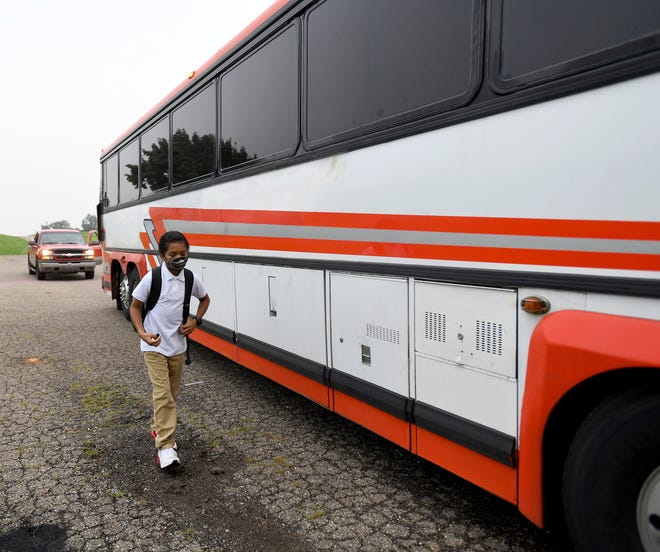A charter bus transports Canton College Preparatory School students, including sixth grader Jaleo Bracken, 11, to school from their bus stop at Harmont Park in Canton.