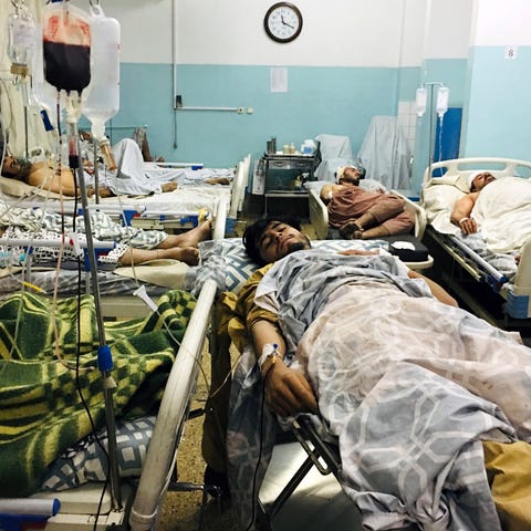 Wounded Afghans lie on a bed at a hospital after a