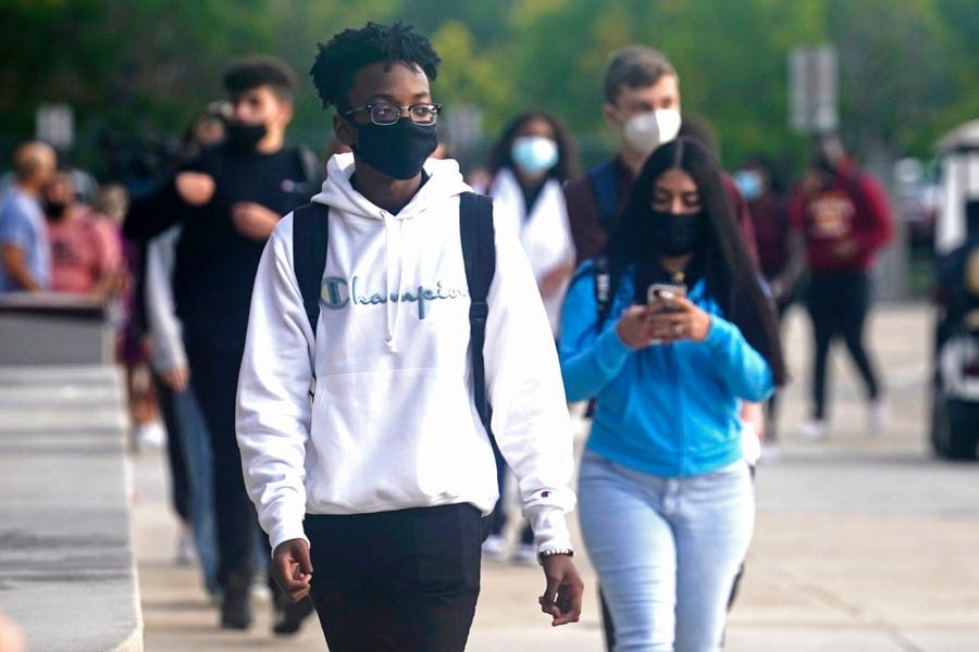 Students at Barbara Coleman Senior High School walk to the campus on their first day of school, Monday, Aug. 23, 2021, in Miami Lakes, Fla. Miami-Dade County public schools require students to wear a mask to prevent the spread of COVID-19.