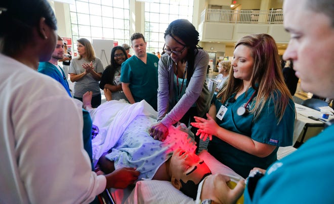 Allison Miller, a nursing student at Shelton State, directs Lillian Jackson, a student at Paul W. Bryant High, as she simulates CPR on a medical mannequin during the West Alabama Worlds of Work at Shelton State on Oct. 12, 2017. A planned health-care focused high school is planned for Demopolis to help ease the acute shortage of health-care workers in Alabama.