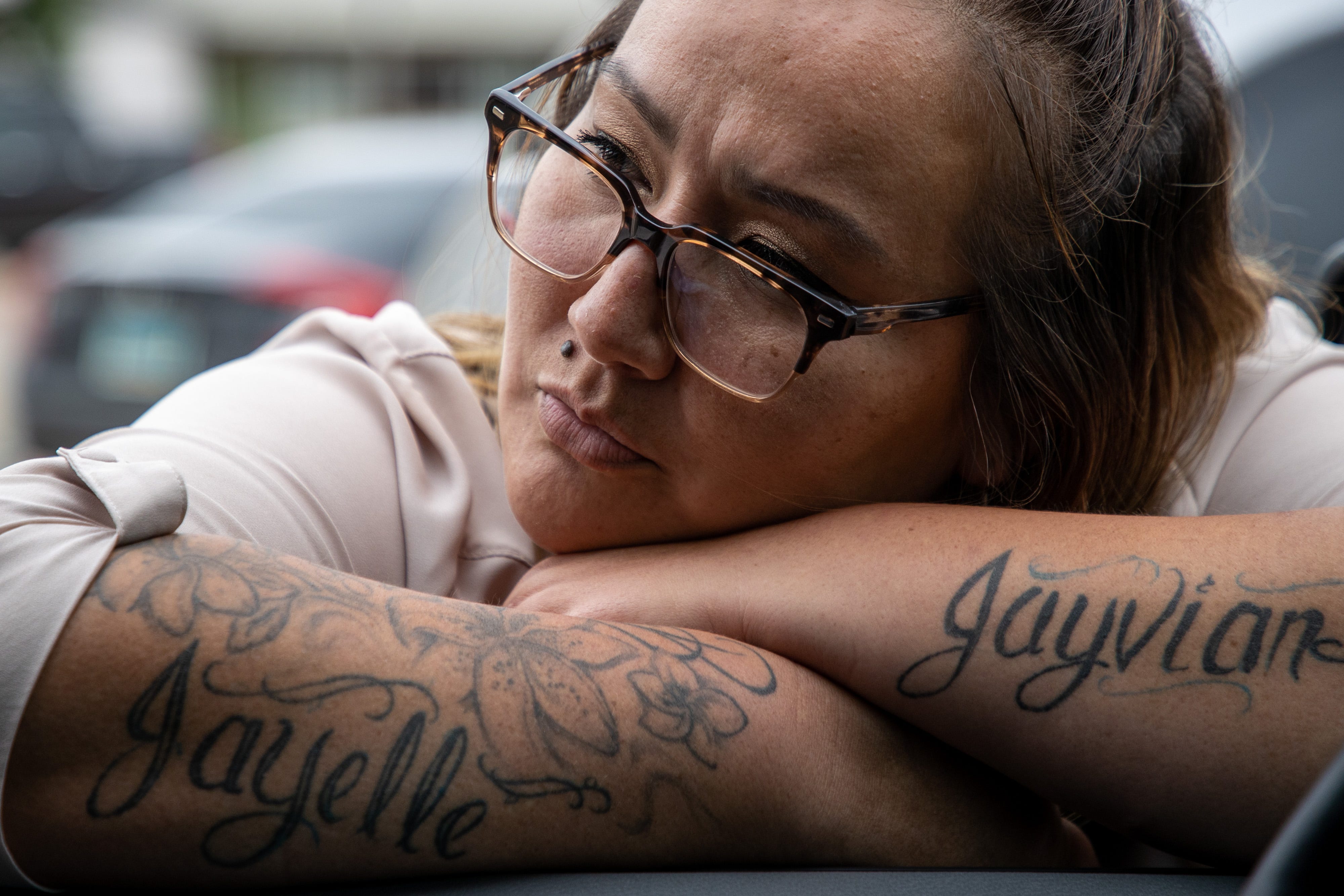 Fort Berthold Reservation resident, Rachelle Baker, leans into the car window of her aunt, MHA Drug Enforcement special agent Dawn White's, cruiser. Baker was a school teacher when White arrested her in 2013 on charges related to heroin. The names of her two children on her forearms help to cover the scars from past intravenous needle use and give her inspiration to stay sober. "She honestly probably saved my life when she arrested me," Baker said of her aunt, special agent Dawn White. Today, Baker works to educate locals on addiction. June 25, 2021