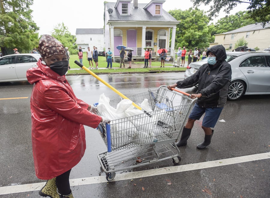 People bring home sandbags at a city run sandbag distribution location at the Dryades YMCA along Oretha Castle Haley Blvd., Friday, August 27, 2021, in New Orleans, as residents prepare for Hurricane Ida.