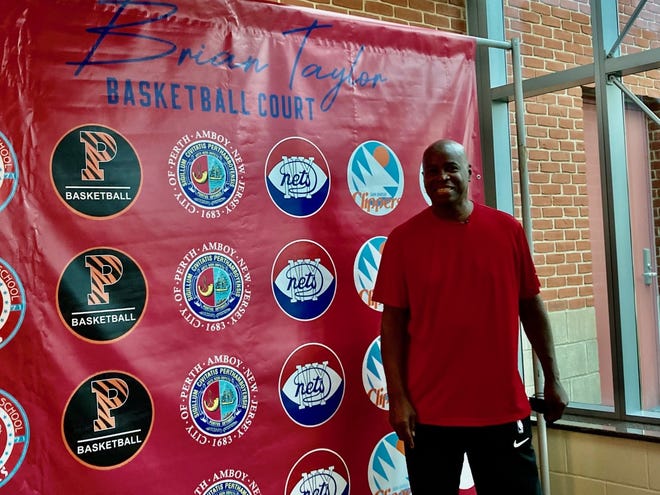Perth Amboy basketball legend Brian Taylor stands in front of a banner listing some of his achievements at Perth Amboy High School, Princeton University Basketball, American Basketball Association New York Nets and the NBA San Diego Clippers.  Perth Amboy opened the Washington Park basketball courts on Saturday for Taylor.