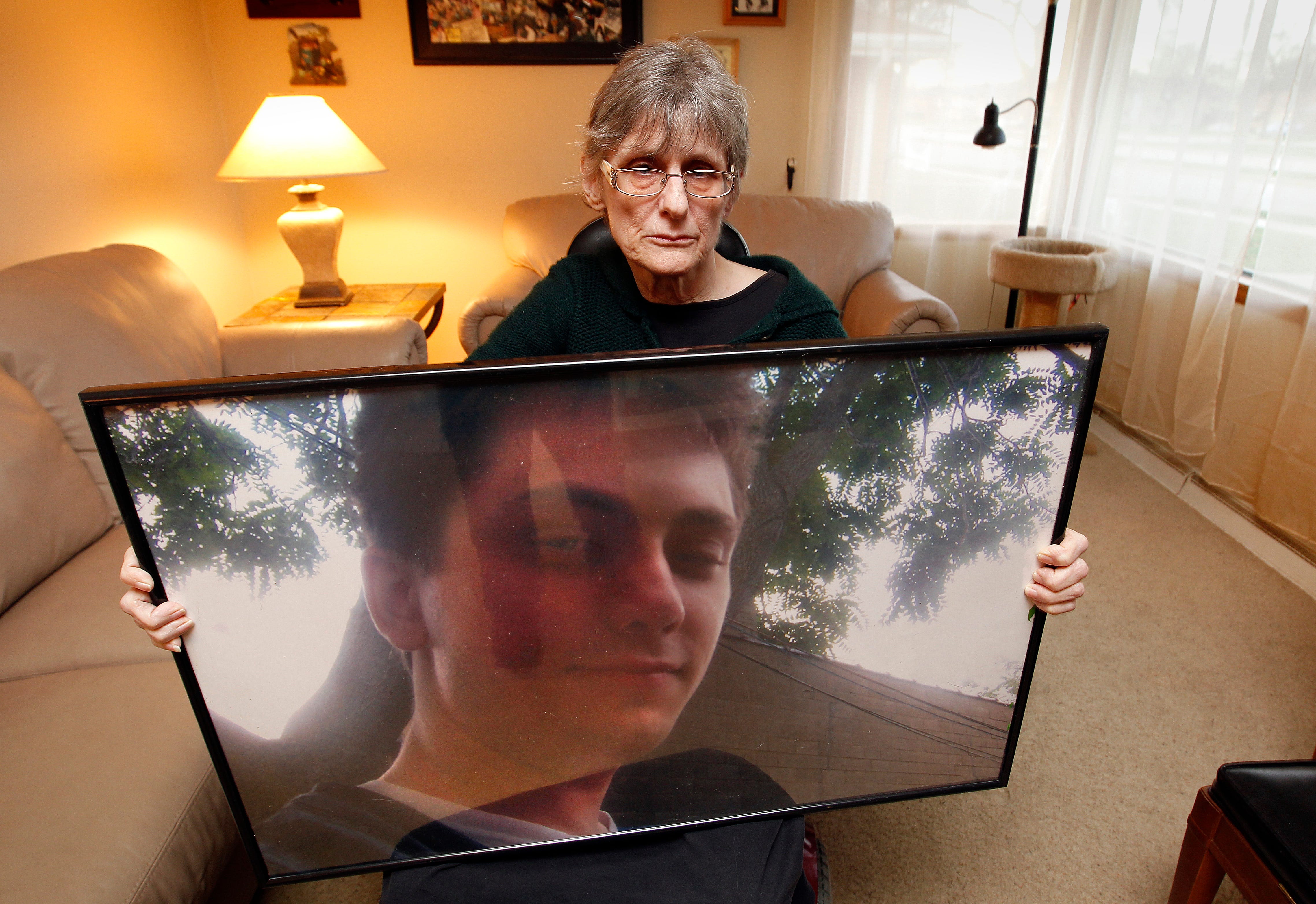 Kathy DeSpears holds a photograph of her son, Matthew DeSpears, not considered sick enough for comprehensive care, overdosed on pills a pharmacy sent him and was found dead on a frozen lawn in December 2011.