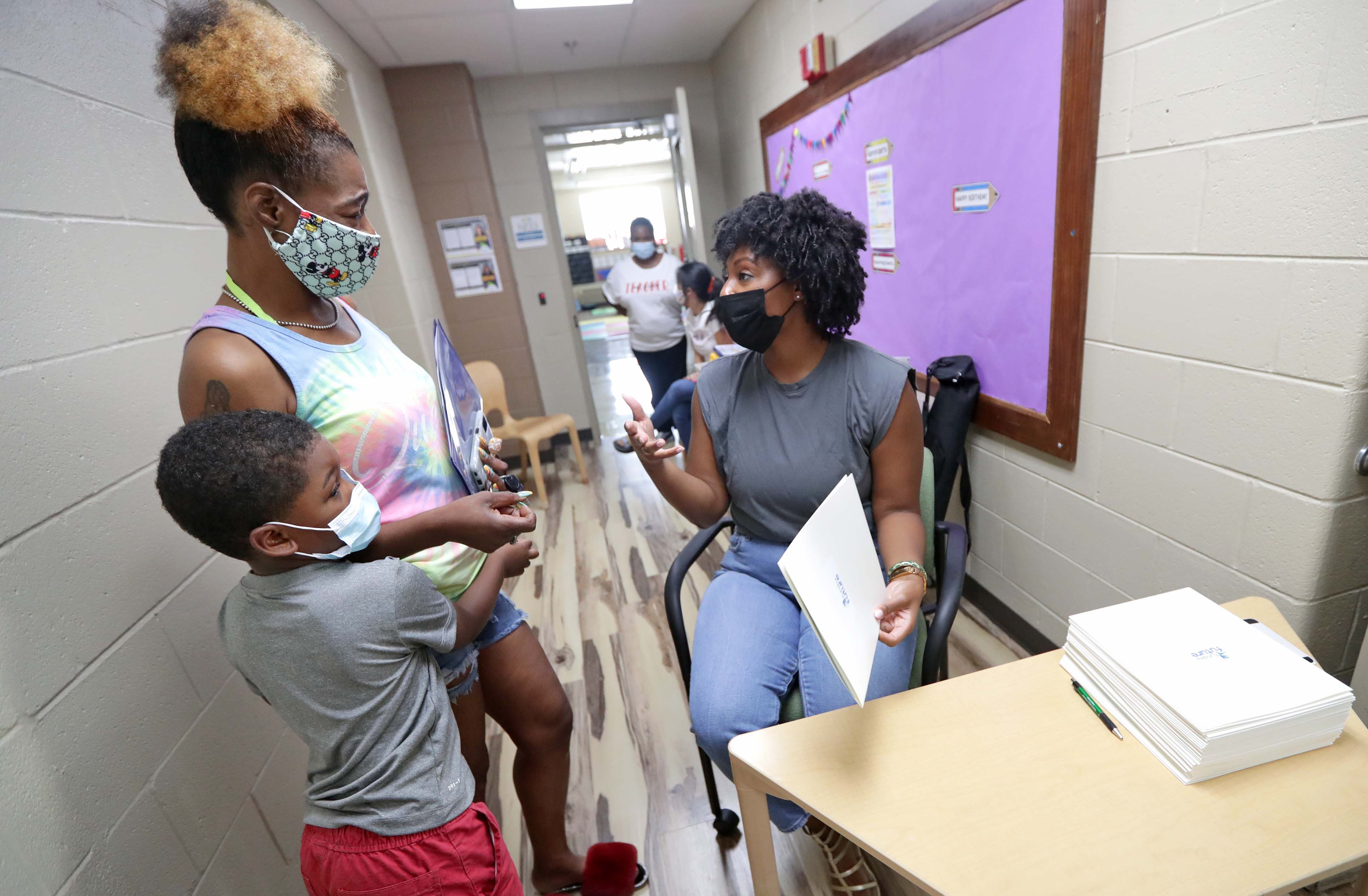 Ashleigh Edgerson, right, manager for Fund My Future Milwaukee, meets Brandi Allen and her 5-year-old son, Javier Tucker, during an open house at Javier's school, Next Door in Milwaukee. Fund My Future wants to open 529 college saving accounts for all K5 students in the city.