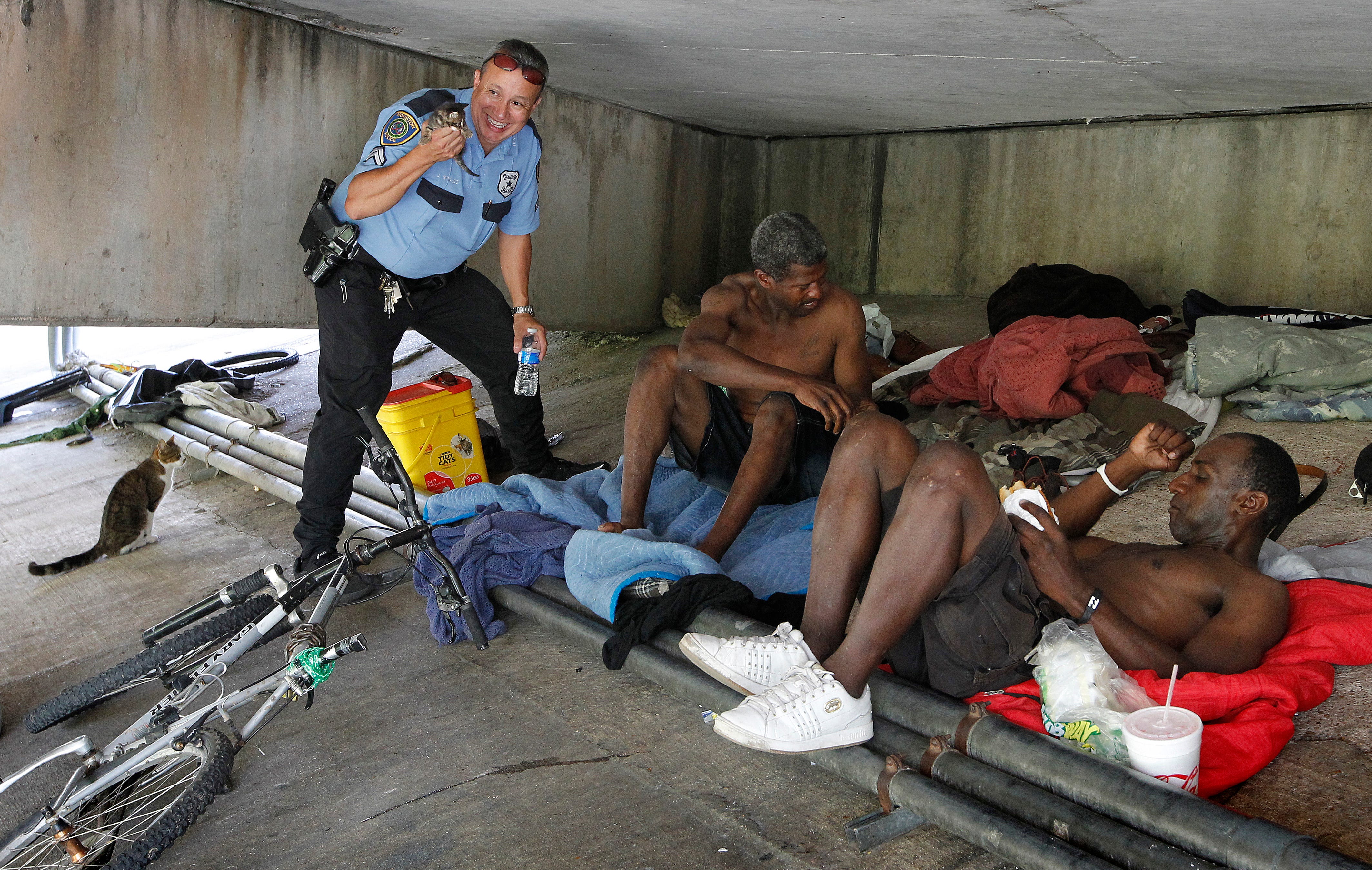 In Houston, every police officer on the force receives Crisis Intervention Training. In Milwaukee, only 20% of those on the force have such training. In this picture from June 2013, Houston police officer Jaime Giraldo holds one of four kittens born to a cat cared for by a couple of homeless men at their camp under a bridge. He and partner Stephen Wick are members of the department's Homeless Outreach Team.