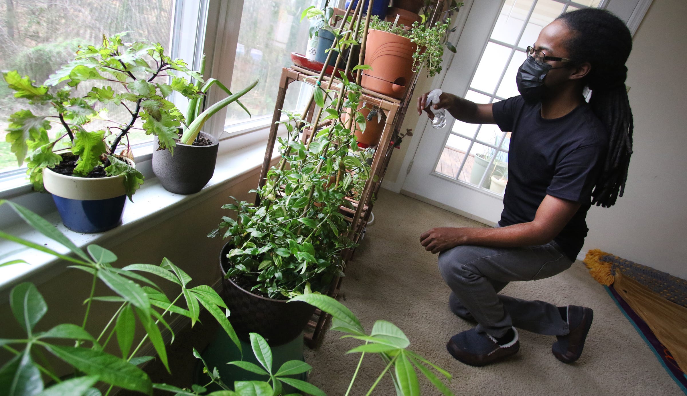 Gaston College student Lyn Holland waters the plants in his apartment on Loblolly PineDrive in Gastonia. The local housing authority, which issued Holland’s voucher, cut his benefits last year. Officials told Holland this spring he would have to move or pay $200 more a month in rent because he did not qualify for a two-bedroom apartment.