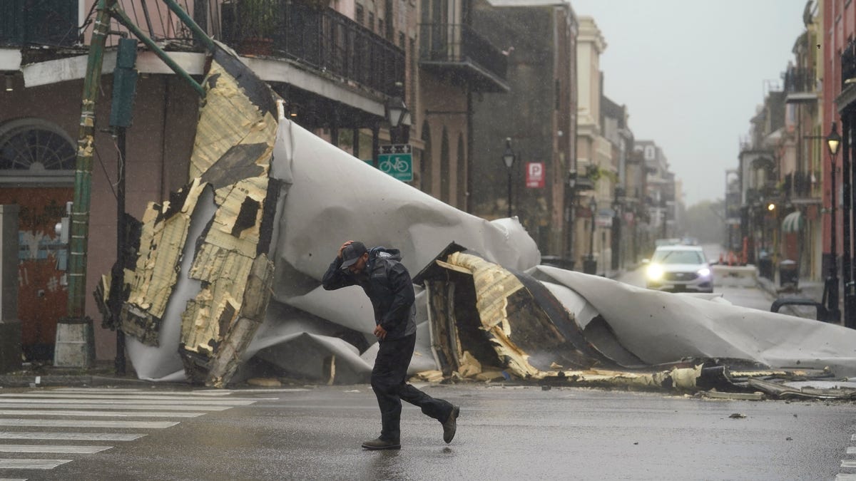 A man passes by a section of roof that was blown off of a building in the French Quarter by Hurricane Ida winds, Sunday, Aug. 29, 2021, in New Orleans. 