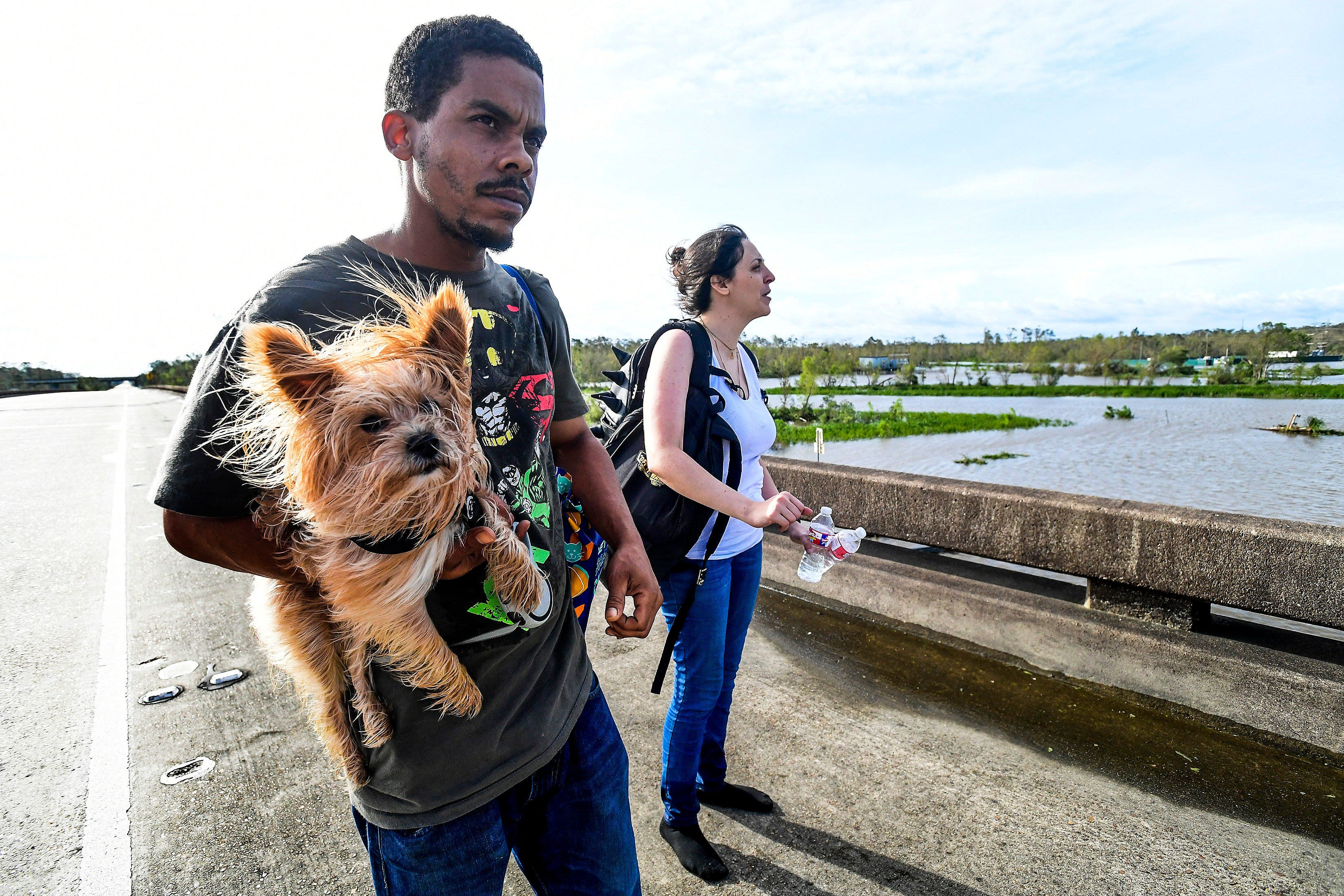 Soloman Smith holds Walle and Jake Sikaffy walk along I-10 after being rescued from their damaged house in LaPlace, La., by a boat on Monday August 30, 2021, after Hurricane Ida came ashore in Louisiana on Sunday August 29, 2021.